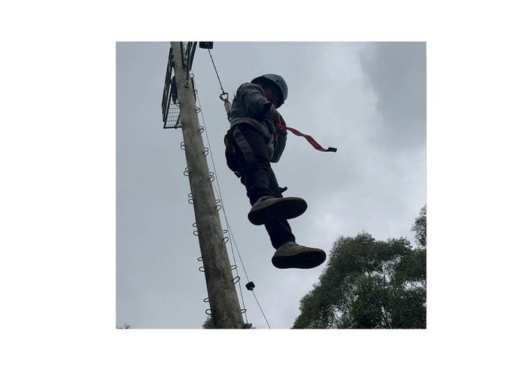 Student connected to a harness dangling in the air