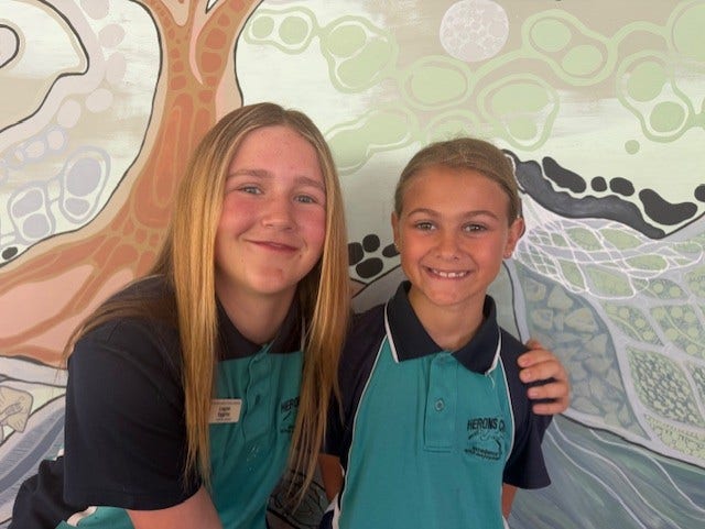 Image of two students (Yr 6 & Yr 3) smiling